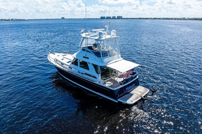 Slide: The Image of 2019 Sabre Flybridge yacht cruising on open water under a clear sky. - 69