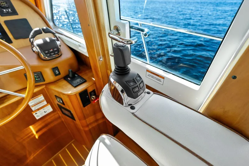 Slide: The Image of 2019 Sabre Flybridge helm with joystick control, overlooking ocean through window. - 9