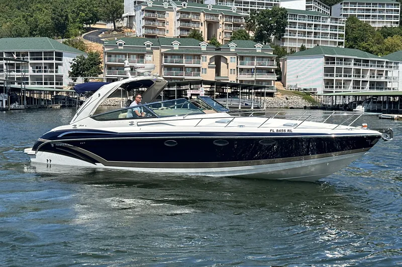 The Image of 2018 Formula 370 Super Sport boat cruising on a lake near waterfront buildings. - 0