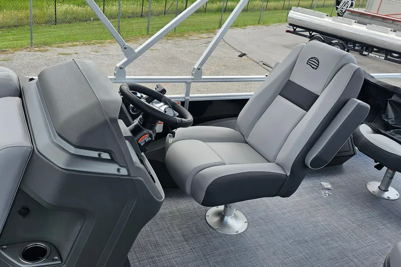 Slide: The Image of 2026 Sun Tracker Sportfish 24 XP3 boat interior with steering wheel and captain's chair. - 10