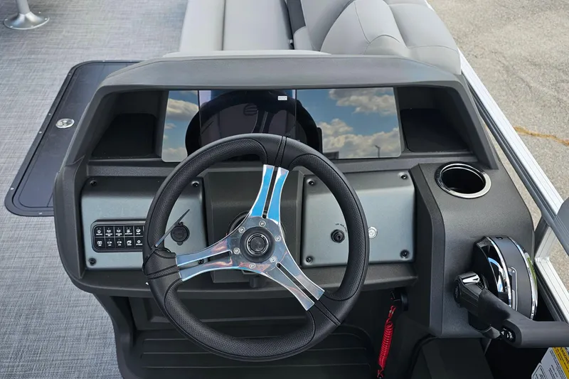 Slide: The Image of 2026 Sun Tracker Sportfish 24 XP3 boat dashboard with steering wheel and control panel. - 12