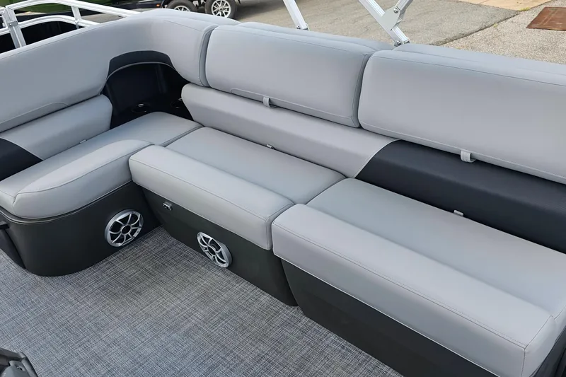Slide: The Image of 2026 Sun Tracker Sportfish 24 XP3 boat interior with gray cushioned seating and built-in speakers. - 16