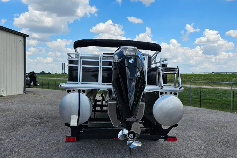 Slide: The Image of 2026 Sun Tracker Sportfish 24 XP3 pontoon boat with outboard motor, parked outdoors. - 3