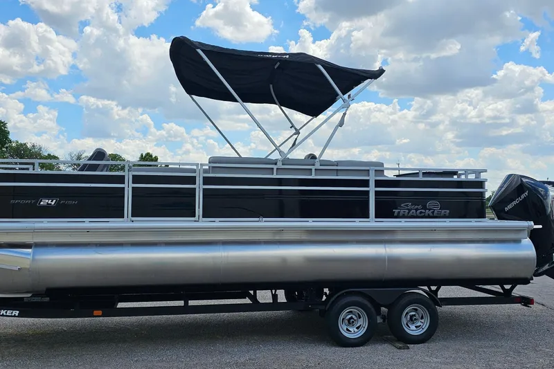 Slide: The Image of 2026 Sun Tracker Sportfish 24 XP3 pontoon boat with canopy on trailer under blue sky. - 5