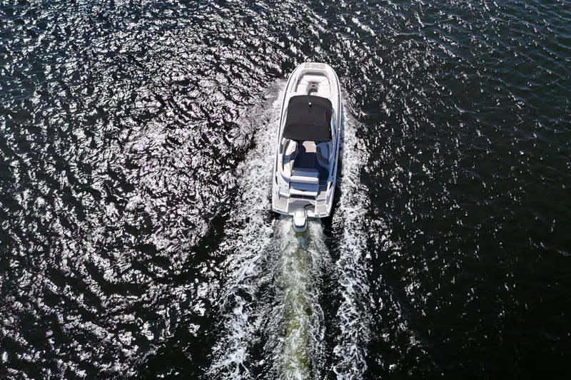 Slide: The Image of Aerial view of 2020 Crownline 24 boat cruising on shimmering water. - 17