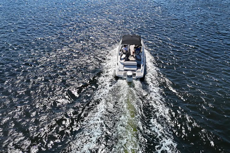 Slide: The Image of 2020 Crownline 24 boat cruising on open water, leaving a wake behind. - 18