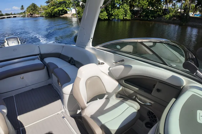 Slide: The Image of 2020 Crownline 24 boat interior with plush seating, cruising on a scenic waterway. - 28