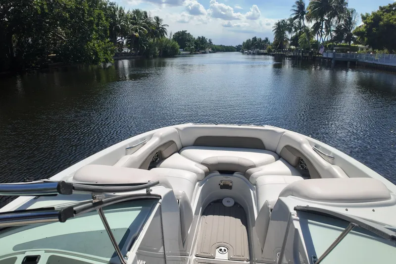 Slide: The Image of 2020 Crownline 24 boat cruising on a scenic, palm-lined waterway. - 31