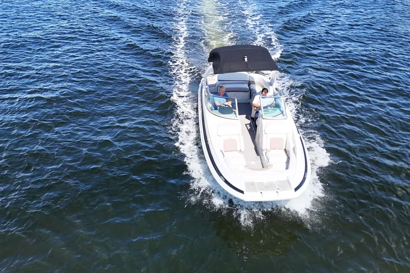 Slide: The Image of 2020 Crownline 24 boat cruising on open water, featuring sleek design and spacious seating. - 5