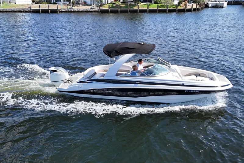 Slide: The Image of 2020 Crownline 24 boat cruising on a sunny day with two passengers. - 8