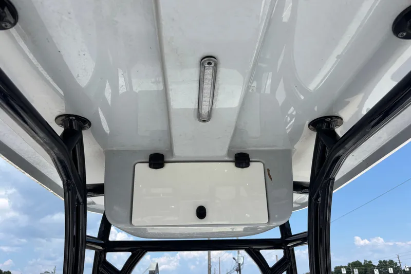 Slide: The Image of 2022 Cape Horn 22 OS boat's overhead console and T-top structure against a blue sky. - 21