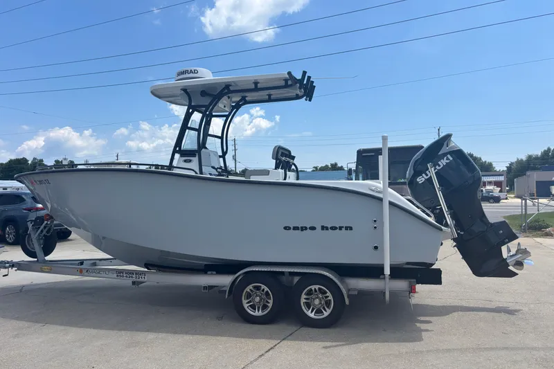 Slide: The Image of 2022 Cape Horn 22 OS boat on trailer with Suzuki outboard motor, parked outdoors. - 5