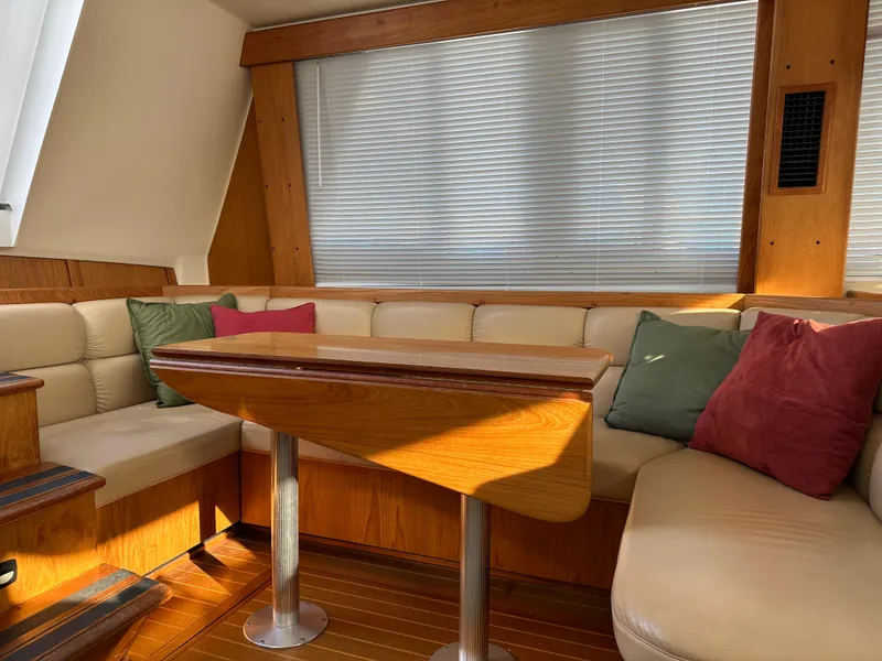 Slide: The Image of Cozy interior of 2000 Mainship 43 Trawler Aft Cabin with seating and wooden table. - 10