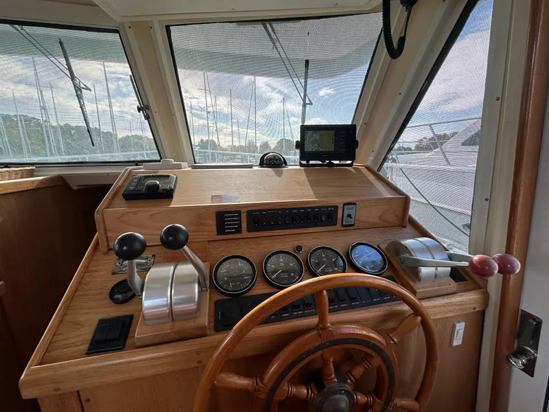 Slide: The Image of 2000 Mainship 43 Trawler Aft Cabin helm with wooden wheel and navigation instruments. - 16