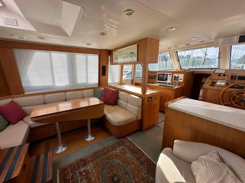 Slide: The Image of Interior of 2000 Mainship 43 Trawler Aft Cabin with cozy seating and wooden accents. - 18