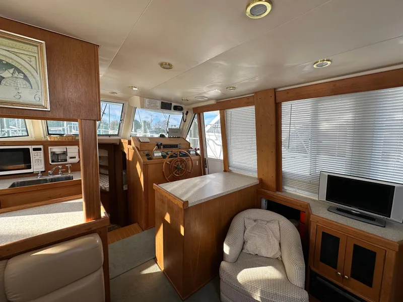 Slide: The Image of Interior of 2000 Mainship 43 Trawler Aft Cabin with cozy seating and helm station. - 20