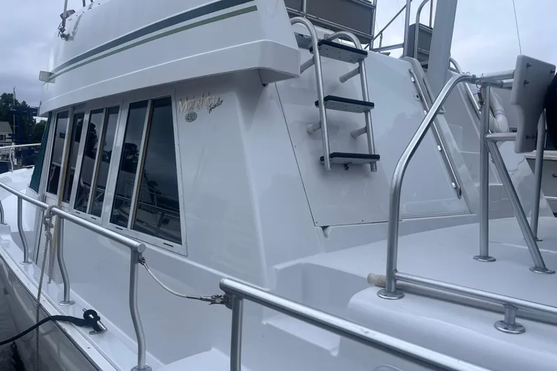 Slide: The Image of 2000 Mainship 43 Trawler Aft Cabin with sleek white exterior and ladder. - 3