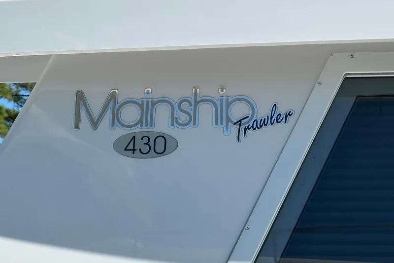 Slide: The Image of Mainship 43 Trawler Aft Cabin 2000 logo on boat exterior. - 30