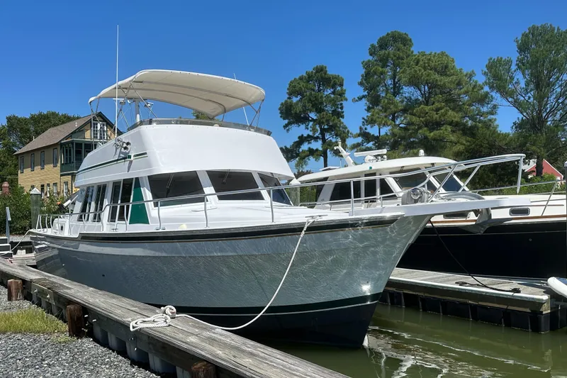 Slide: The Image of 2000 Mainship 43 Trawler Aft Cabin docked, featuring sleek design and spacious upper deck. - 5