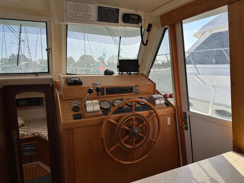 Slide: The Image of Mainship 43 Trawler Aft Cabin 2000 helm with wooden wheel and navigation instruments. - 7