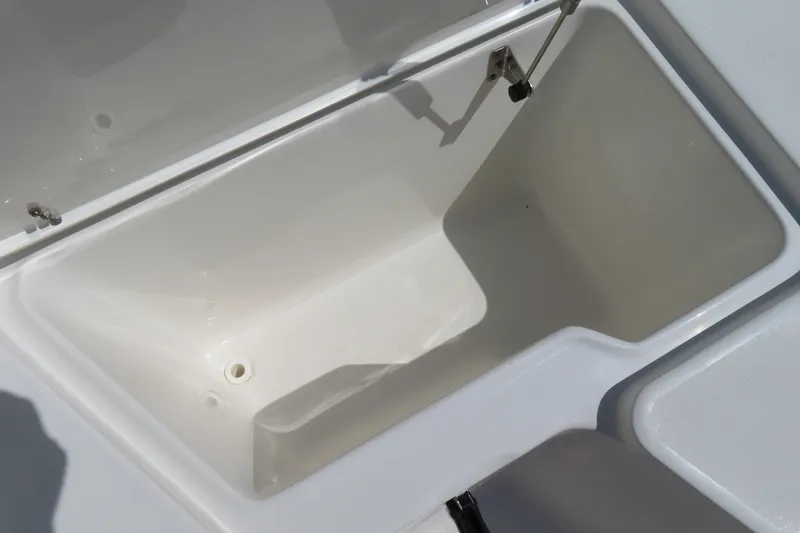 Slide: The Image of Open storage compartment on 2019 Sea Hunt Ultra 225 boat, featuring a clean, white interior. - 10