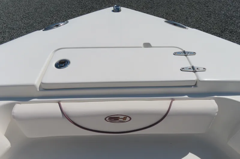 Slide: The Image of 2019 Sea Hunt Ultra 225 boat bow with storage compartment and cushioned seating. - 12