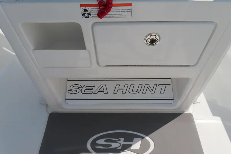 Slide: The Image of 2019 Sea Hunt Ultra 225 boat interior with storage compartment and logo. - 23