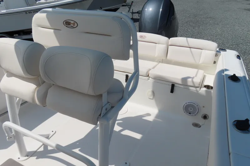 Slide: The Image of 2019 Sea Hunt Ultra 225 boat interior with cushioned seating and motor. - 26