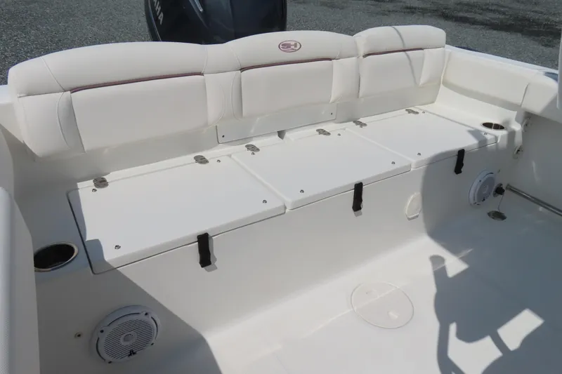 Slide: The Image of 2019 Sea Hunt Ultra 225 boat interior with white seating and storage compartments. - 30