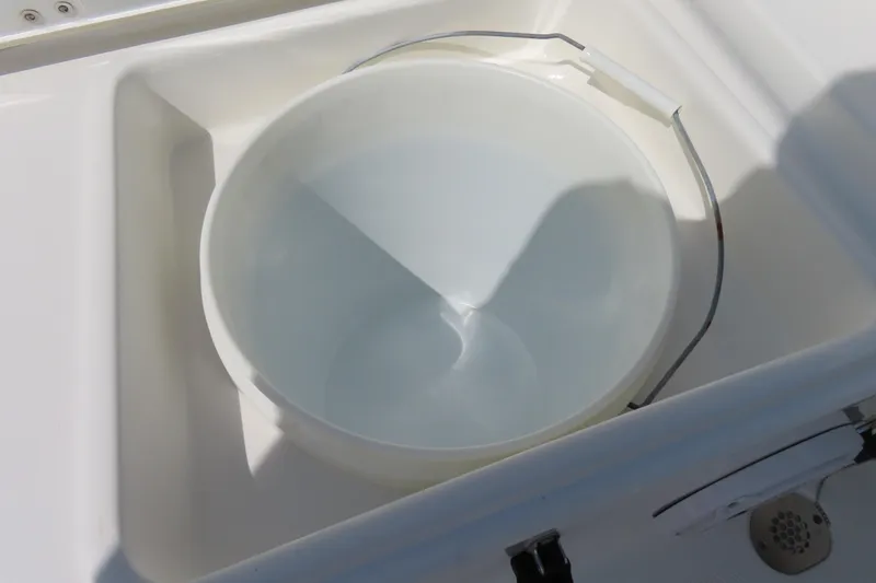 Slide: The Image of White bucket in a compartment on a 2019 Sea Hunt Ultra 225 boat. - 34