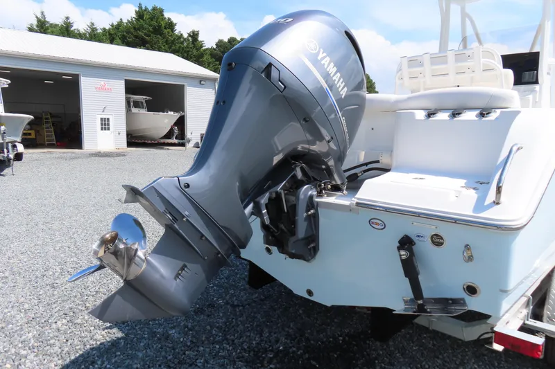 Slide: The Image of 2019 Sea Hunt Ultra 225 with Yamaha outboard motor in a boatyard setting. - 5