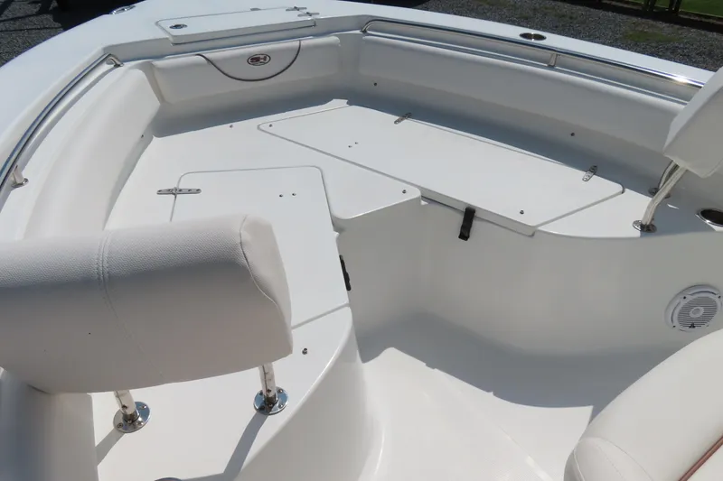 Slide: The Image of 2019 Sea Hunt Ultra 225 boat interior with white seating and storage compartments. - 8