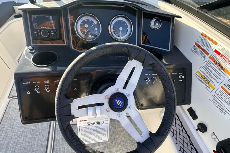 Slide: The Image of 2025 Bayliner VR5 Bowrider OB dashboard with steering wheel and control panel. - 13