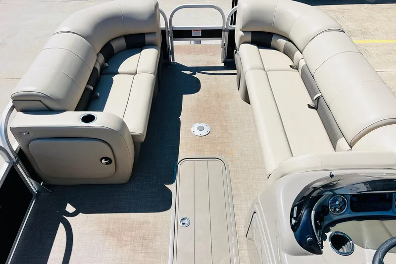 Slide: The Image of 2022 Sun Tracker SportFish 22 XP3 pontoon boat interior with beige seating and steering console. - 11