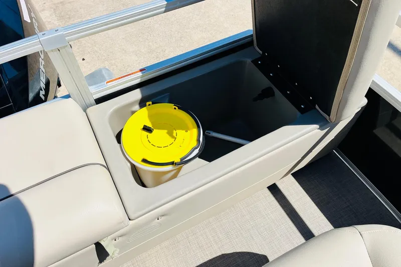 Slide: The Image of Open storage compartment on 2022 Sun Tracker SportFish 22 XP3 boat with yellow bucket inside. - 41