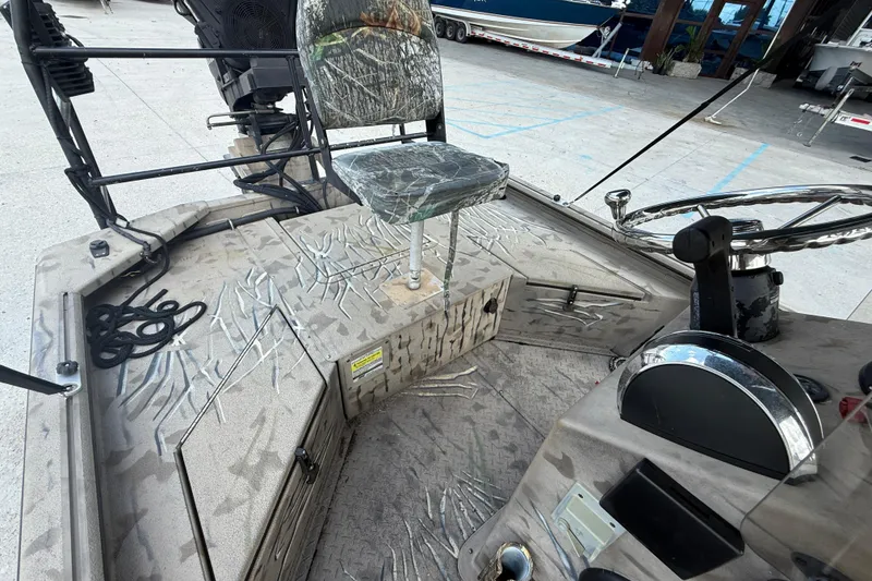Slide: The Image of 2016 SeaArk 180 Mudrunner boat interior with camo seat and steering wheel. - 10