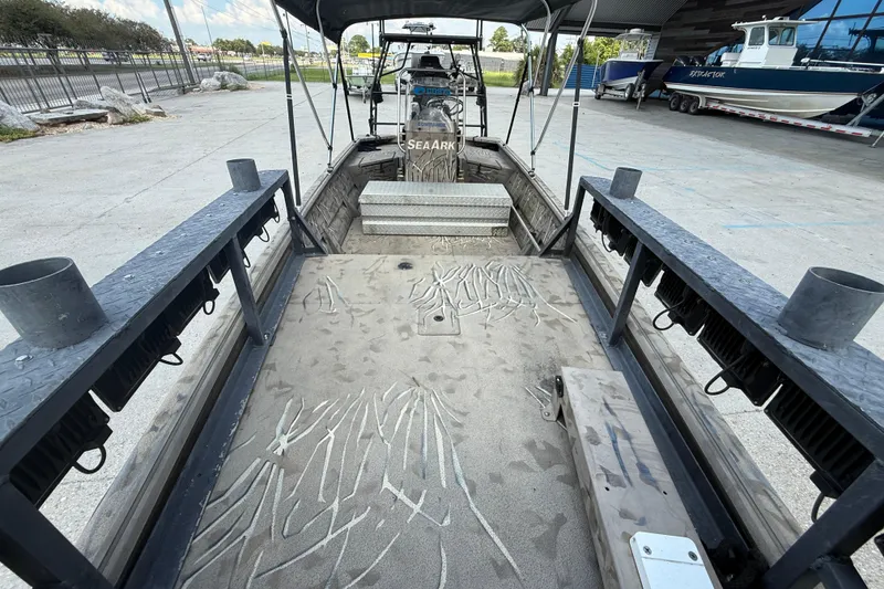 Slide: The Image of 2016 SeaArk 180 Mudrunner boat interior with canopy, docked outdoors. - 9