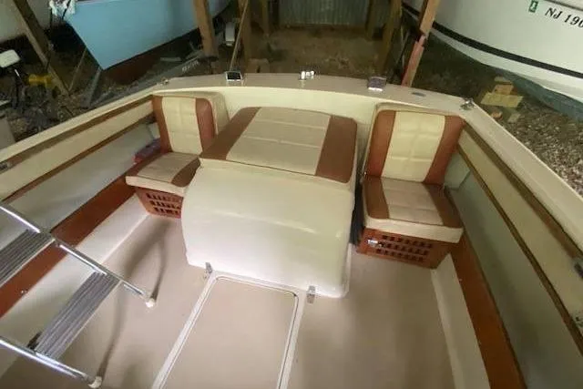 Slide: The Image of 1968 HILINER Sportsman boat interior with beige and brown seating, ladder, and storage compartments. - 11