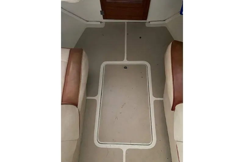 Slide: The Image of 1968 HILINER Sportsman boat interior with beige flooring and brown-trimmed seats. - 13