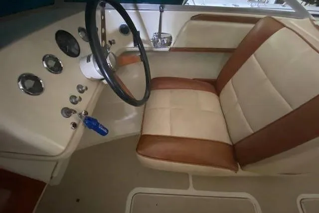 Slide: The Image of 1968 HILINER Sportsman boat interior with vintage steering wheel and beige-brown seating. - 7