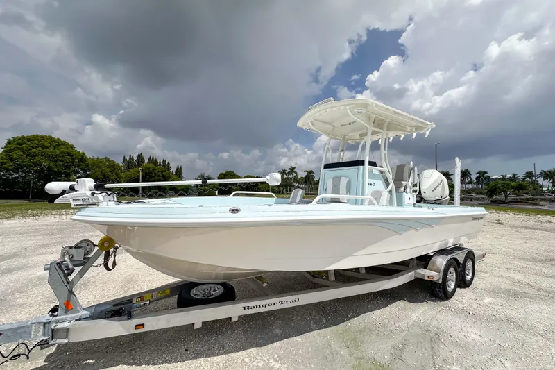 The Image of 2025 Ranger 2360 Bay boat on trailer under cloudy sky. - 0
