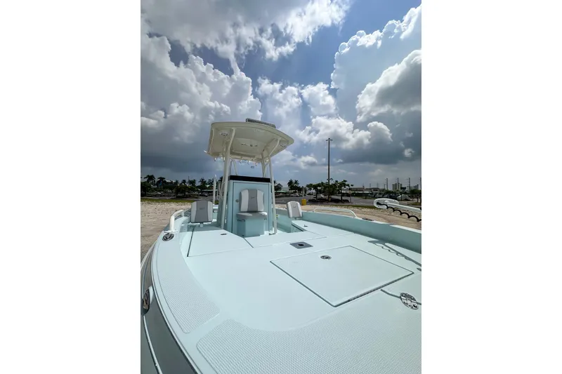 Slide: The Image of 2025 Ranger 2360 Bay boat under cloudy sky, showcasing spacious deck and modern design. - 11