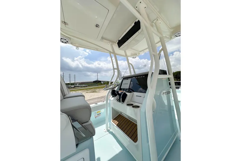 Slide: The Image of 2025 Ranger 2360 Bay boat interior with modern console and seating under a clear sky. - 13