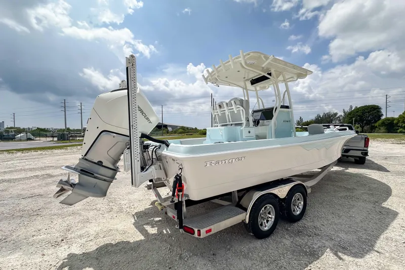 Slide: The Image of 2025 Ranger 2360 Bay boat on trailer, featuring a powerful outboard motor. - 16