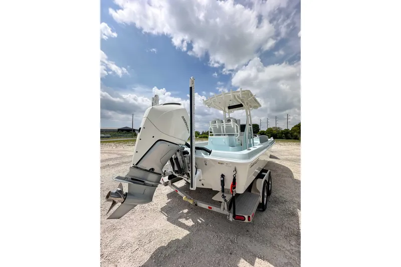 Slide: The Image of 2025 Ranger 2360 Bay boat on trailer under cloudy sky. - 17