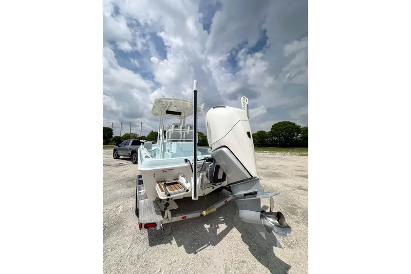 Slide: The Image of 2025 Ranger 2360 Bay boat on trailer, parked outdoors under cloudy sky. - 18
