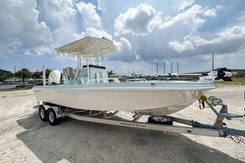 Slide: The Image of 2025 Ranger 2360 Bay boat on trailer under cloudy sky. - 19