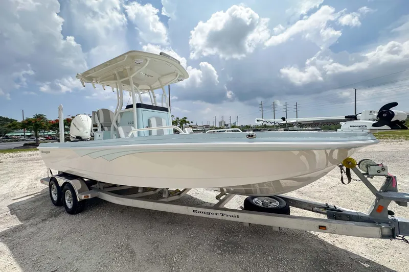 Slide: The Image of 2025 Ranger 2360 Bay boat on trailer under cloudy sky. - 20