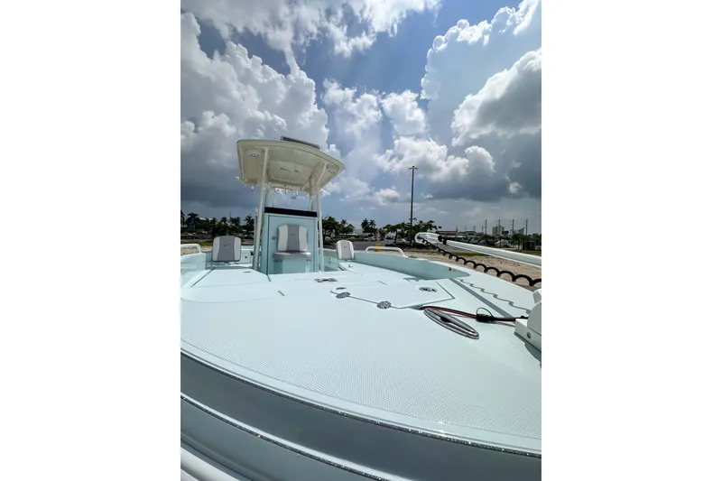 Slide: The Image of 2025 Ranger 2360 Bay boat under cloudy sky, showcasing spacious deck and modern design. - 22