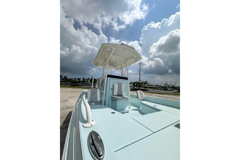 Slide: The Image of 2025 Ranger 2360 Bay boat under cloudy sky, showcasing sleek design and spacious deck. - 23
